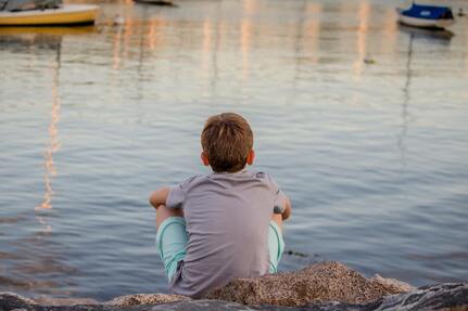 Picture of child sitting by water